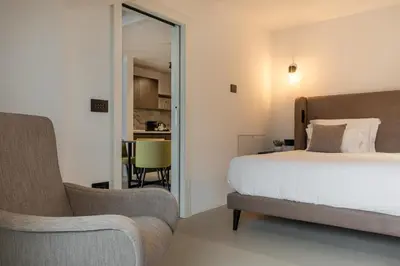 a bedroom with a bed and a couch and a chair at Residence - Palais Hörtenberg in Bolzano
