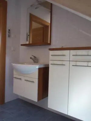a white bathroom with a sink and a mirror at Tauberhof Apartments in Bressanone