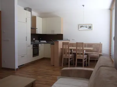 a kitchen and living room with a table and chairs at Tauberhof Apartments in Bressanone