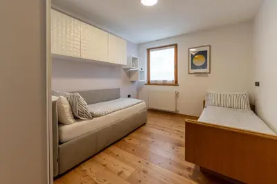 a living room with a couch and a bed at CASA BEBA - 2 camere, 2 bagni, parcheggio Dolomiti Affitti in Cavalese