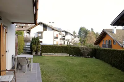 a patio with a table and chairs in a yard at CASA BEBA - 2 camere, 2 bagni, parcheggio Dolomiti Affitti in Cavalese