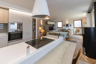 a kitchen and living room with a white counter top at CASA BEBA - 2 camere, 2 bagni, parcheggio Dolomiti Affitti in Cavalese