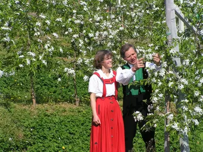 a man and a woman standing next to a tree at Unterbrunnerhof in Lana