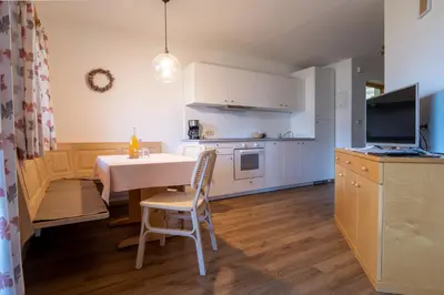 a kitchen and dining room with a table and chairs at Unterbrunnerhof in Lana