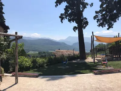 a patio with a hammock and a view of mountains at Goldengel Design-Suiten Frieda Maria im Herzen von Kaltern in Caldaro
