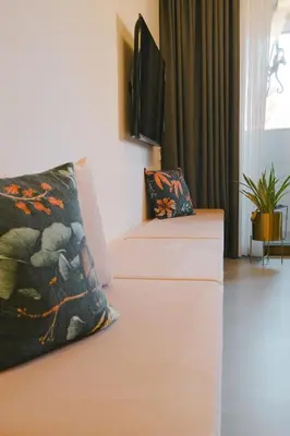 a living room with a couch and a flat screen tv at Goldengel Design-Suiten Frieda Maria im Herzen von Kaltern in Caldaro