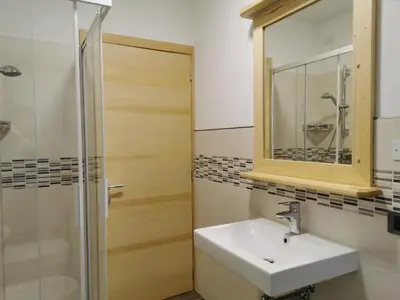 a bathroom with a sink and a shower and a mirror at App. Monte Pore - Agriturismo La Majon in Colle Santa Lucia