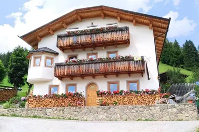 a house with a balcony with flowers on it at App. Monte Pore - Agriturismo La Majon in Colle Santa Lucia