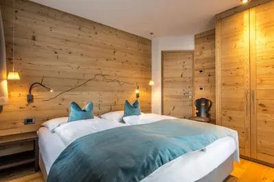 a wooden building with a mountain in the background at Chalet Prades Dolomiti Lodges in La Villa
