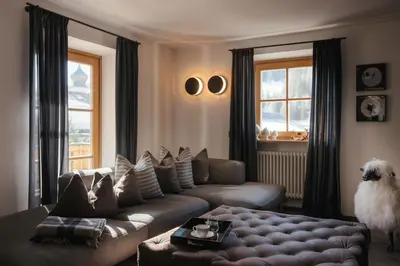 a living room with a couch and a dog in it at The Grey Lodge at Bosco Verde in San Cassiano