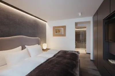 a bedroom with a bed and a television in it at The Grey Lodge at Bosco Verde in San Cassiano