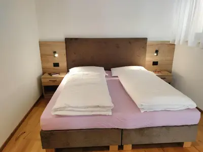 a bed with two pillows on it in a room at Ciüf de Munt in Badia