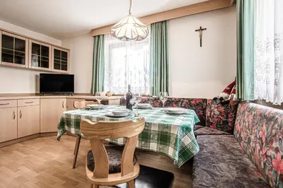 a dining room with a table and a couch at Ciüf de Munt in Badia