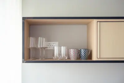 a shelf with glasses and vases on it at Solis Apartments in Lana