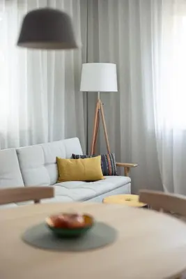 a living room with a white couch and a lamp at Solis Apartments in Lana