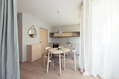 a kitchen with a table and chairs in a room at Solis Apartments in Lana