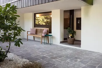 a patio with a bench and a table and a window at Solis Apartments in Lana