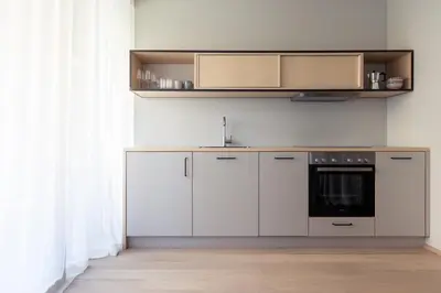 a kitchen with white cabinets and a black oven at Solis Apartments in Lana