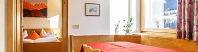 a room with a bed and a window and a table at Galreidhof in Funes