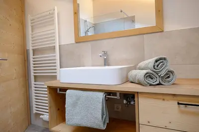 a bathroom with a sink and a mirror and towels at Der Luemerhof in Marlengo
