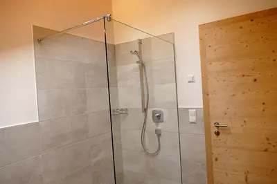 a shower with a glass door in a bathroom at Der Luemerhof in Marlengo