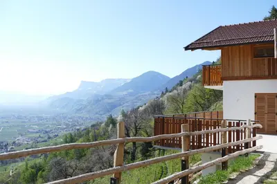 a balcony of a house with a view of a valley at Der Luemerhof in Marlengo