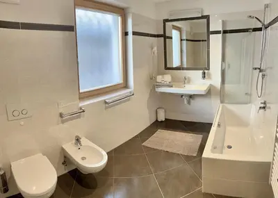 a bathroom with a toilet and a sink and a shower at Residence Ravisa Dolomites in Selva di Val Gardena