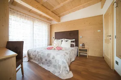 a bedroom with a bed with a pink bow on it at Residence Ravisa Dolomites in Selva di Val Gardena