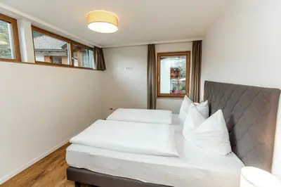a bedroom with a bed with white sheets and pillows at Tyrol Living & Cafe in Nova Levante