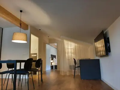 a dining room and living room with a table and chairs at Tyrol Living & Cafe in Nova Levante