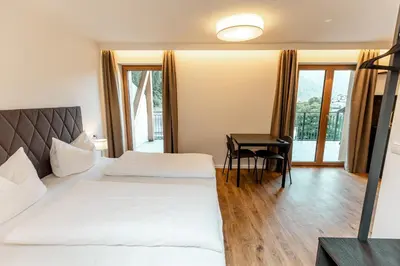 a hotel room with two beds and a table at Tyrol Living & Cafe in Nova Levante