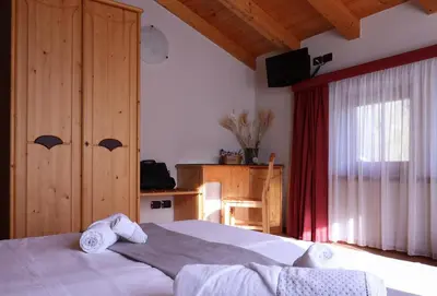 a bedroom with a bed with towels on it at hotel Parco Pineta in Cavareno
