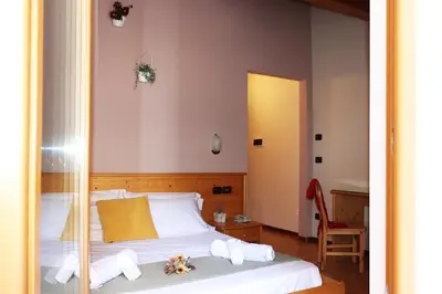 a bedroom with a bed with towels on it at hotel Parco Pineta in Cavareno
