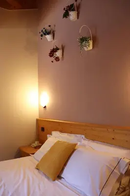 a bedroom with a bed with two baskets on the wall at hotel Parco Pineta in Cavareno