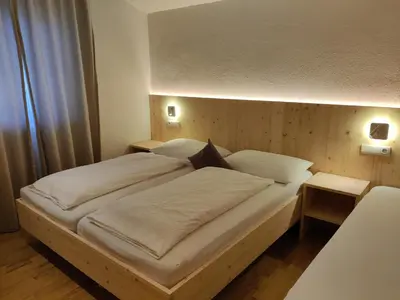 a large bed in a bedroom with two tables at Residence Klementhof 3 in Fiumes
