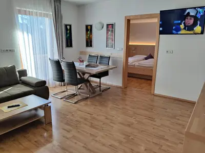a living room with a table and chairs and a bedroom at Residence Klementhof 3 in Fiumes