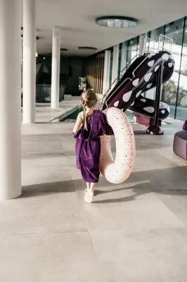 a little girl walking down a hallway talking on a cell phone at Hotel Familiamus in Maranza