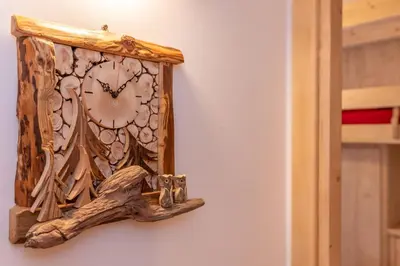 a wooden clock hanging on a wall at Chalet Laura in Alleghe