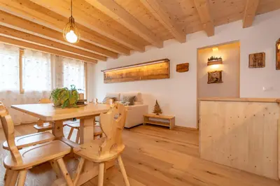 a dining room with a wooden table and chairs at Chalet Laura in Alleghe