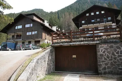 a large building with a garage on the side of a road at Residence Roacia in Alba di Canazei