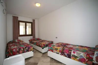 a bedroom with two beds and a window at Residence Roacia in Alba di Canazei