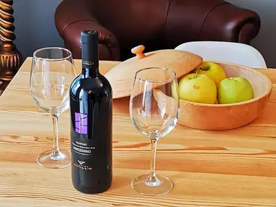 a bottle of wine sitting on a table with two wine glasses at Villetta Italia IT.CU in Merano