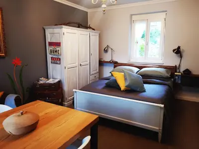 a bedroom with a bed with a table and a window at Villetta Italia IT.CU in Merano
