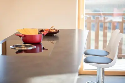 a table with a chair and a bowl of pasta at Appartement Marlene in Appiano sulla Strada del Vino