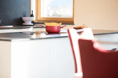 a red bowl of pasta on a counter in a kitchen at Appartement Marlene in Appiano sulla Strada del Vino