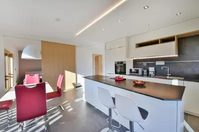a kitchen with red and white chairs and a counter at Appartement Marlene in Appiano sulla Strada del Vino