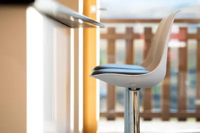 a white chair with a blue seat on a balcony at Appartement Marlene in Appiano sulla Strada del Vino