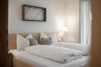 a bedroom with two beds and a mirror on the wall at Oberzerod Apartments in Siusi