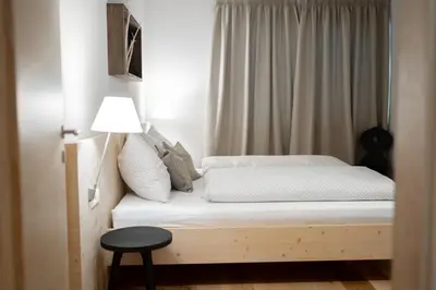 a bedroom with a bed with a lamp and a table at Oberzerod Apartments in Siusi