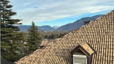 a roof of a house with mountains in the background at NEW Suite mar e monti in Appiano sulla Strada del Vino